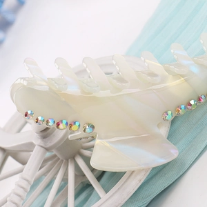 Macro shot of large acetate hair claw with iridescent finish and colorful rhinestones