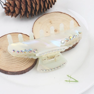 Macro view of colorful rhinestones on a pearlescent white acetate large hair claw clip