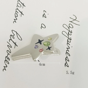 Dettaglio di un fermaglio per capelli a stella in argento opaco con zirconi colorati