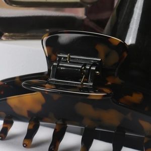 Close-up of tortoise shell pattern acetate hair claw with sturdy golden metal spring