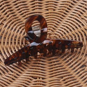 Close-up of tortoise shell hair claw clip with golden Barrette La France engraving