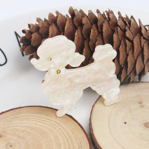 Macro detail of white teddy dog hair clip with glitter acetate texture on wood base