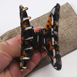 Close-up of a large tortoiseshell hair claw clip with a glossy finish and metal spring