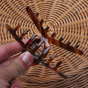 Macro shot of large acetate hair claw clip with classic amber tortoiseshell texture
