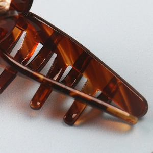 Close-up of tortoise shell pattern and tooth structure on acetate shark hair claw clip
