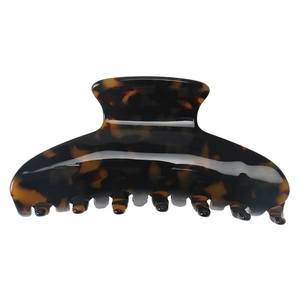 Close-up of glossy amber tortoiseshell texture on large french style claw clip