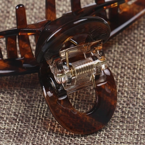 Close-up of tortoise shell hair claw showing amber texture and metal spring mechanism