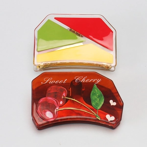 Detail view of large acetic acid hair claws with cherry pattern and colorful geometric blocks