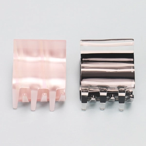 Détail de deux pinces à cheveux carrées moyennes en acrylique à rayures et rose perle