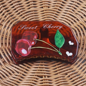 Detail of amber acetate hair claw with red cherry prints and Sweet Cherry text