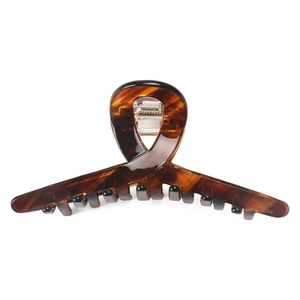 Detailed close-up of amber acetate claw clip with a secure metal spring and gold logo