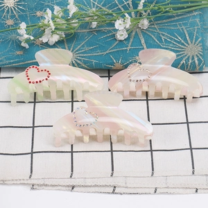 Three large acetate hair claws with iridescent finish and rhinestone heart designs