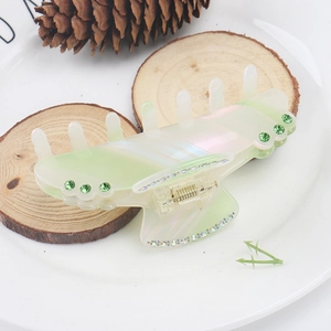 Detail of a large pearlescent green acetate hair claw clip with crystal rhinestones