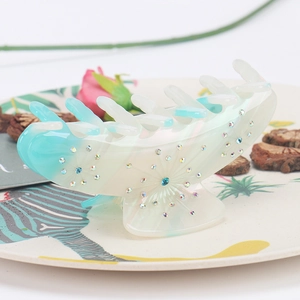 Detailed view of large acetate hair claw with gradient blue finish and rhinestones