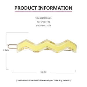 Macro detail of wave acetate hair clip with size specs and yellow cellulose material