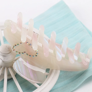 Detail of a large cream acetate hair claw with pink gradient tips and heart rhinestones