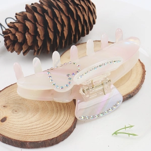 Detail of large acetate hair claw with crystal heart pattern and pearlescent finish
