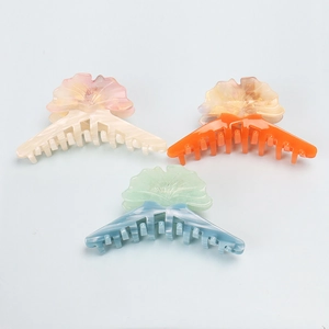 Trois pinces à cheveux en acétate avec design de feuille de ginkgo en crème, orange et bleu