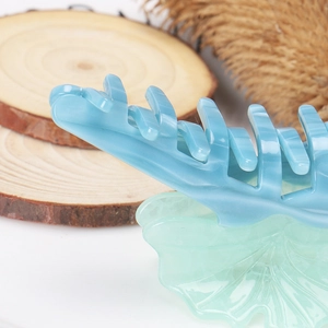 Détail d'une pince à cheveux en acétate effet marbre avec motif feuille de ginkgo