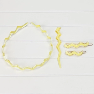 Flat lay of yellow translucent acetic acid hair clip set and wavy headband on wood