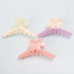 Close-up of three large acetate shark hair claws with marble texture in macaron colors