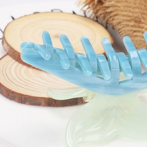 Macro shot of bicolour acetate hair claw featuring marble sky blue and translucent green