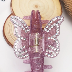 Détail de la pince à cheveux papillon violette pailletée avec ailes en strass blanc