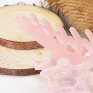 Close-up of pink translucent maple leaf shark clip with marbled resin texture and teeth
