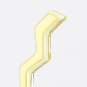Macro shot of French acetate lightning hair clip showing layered yellow and white resin detail