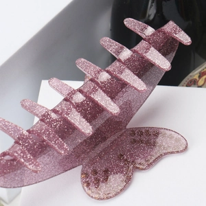 Gros plan sur la pince à cheveux papillon en acrylique violet avec paillettes brillantes