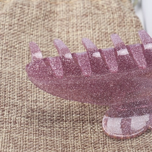 Vue détaillée du fini pailleté violet et des strass étincelants sur la pince à cheveux