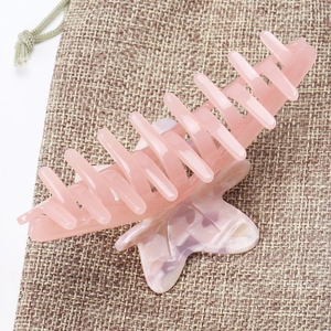 Detailed macro view of large pink maple leaf acetate hair claw clip with marble texture