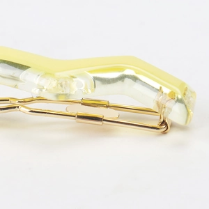 Macro shot of French acetate hair clip with wavy resin detail and gold metal base