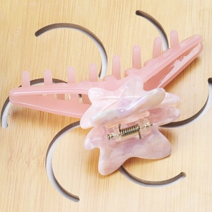 Detail of pink jelly maple leaf claw clip with pearly marble star pattern and strong spring