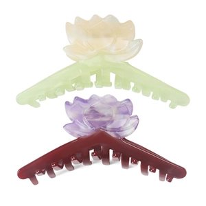 Détail de grandes pinces à cheveux lotus en acétate avec dégradé de vert et de violet