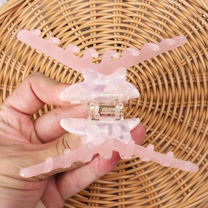 Detail of pink marble acetate hair claw clip showing durable metal spring and large size teeth