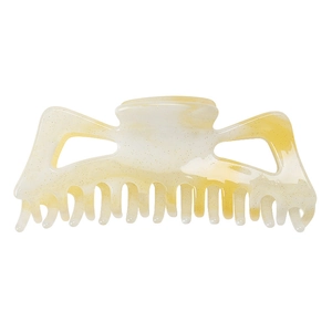 Détail macro d'une grande pince à cheveux marbrée jaune avec finition pailletée dorée