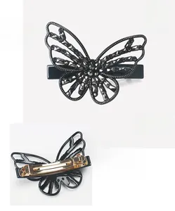 Detail view of acetate butterfly hair clip with grey crystals and gold spring clip