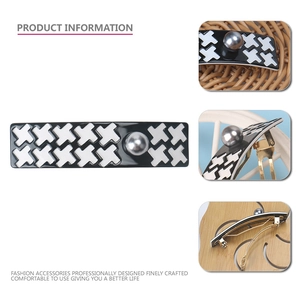 Detail view of houndstooth hair clip with white X pattern and inlaid center pearl