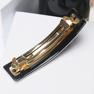Detail of gold-plated metal spring mechanism and France engraving on hair clip
