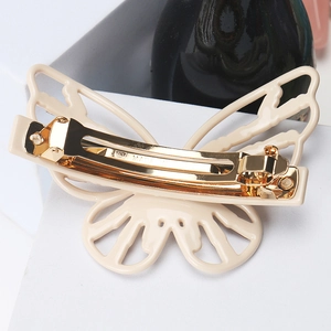 Detail of a butterfly hair clip in cream beige with a golden spring metal fastener