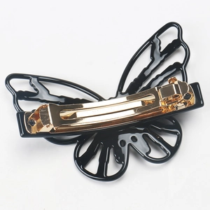 Detail of a black butterfly hair clip with a sturdy gold metal spring mechanism back