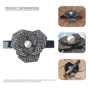 Barrette camélia noire élégante avec strass argentés et centre en perle nacrée