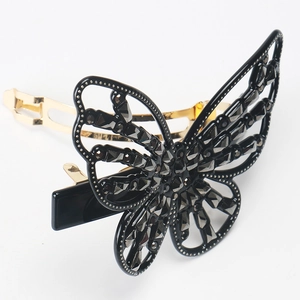 Detailed side view of butterfly hair clip featuring dark crystals and golden metal base