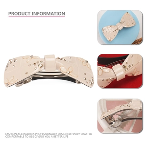 Elegant beige acetate bow hair clip with sparkling rhinestones and floral accents