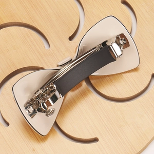 Detail of elegant cream acetate bow hair clip with black anti-slip rubber-coated metal spring