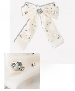 Détail macro d'une grande barrette à nœud en organza avec cristaux et dimensions 19x18cm