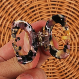 Dettaglio di una piccola clip per capelli in acetato con motivo tartarugato viola