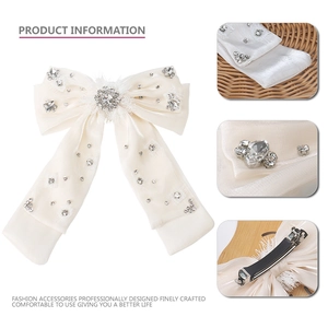 Barrette nœud géant en satin blanc avec des strass brillants et des détails de plumes