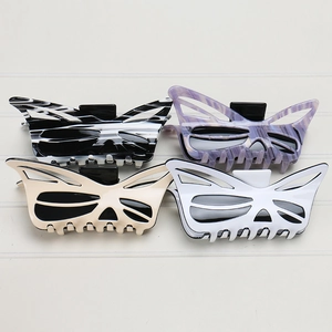 Detail showing oversized acetic acid butterfly hair claws in four different marble patterns